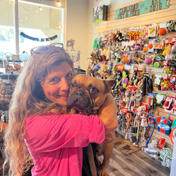 Woman holding her dog inside of the store